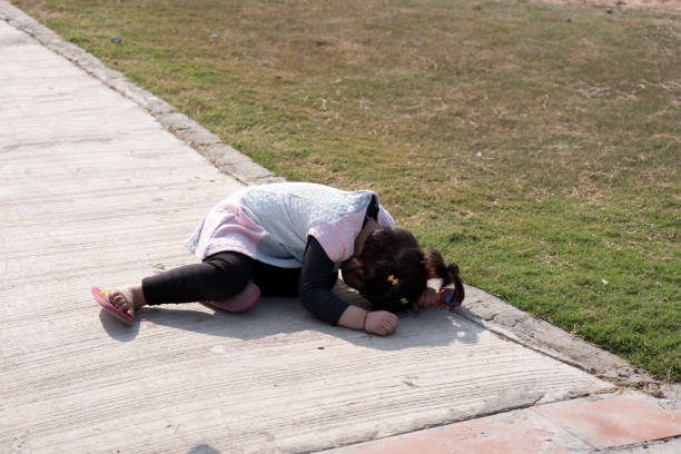 Little girl hiding her face in the ground. Little girl hiding her face in the ground. sad girl crouching stock pictures, royalty-free photos & images
