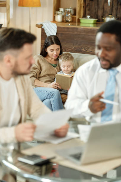 istock Woman reading book with kid on couch 1203391743