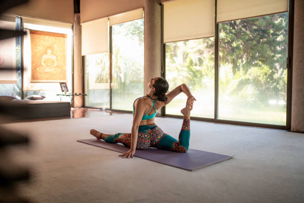 istock Young woman practicing yoga in the yoga studio 1203399049