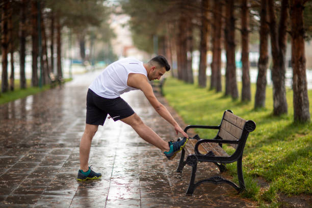 istock Young man stretching his leg on a rain. 1203399719