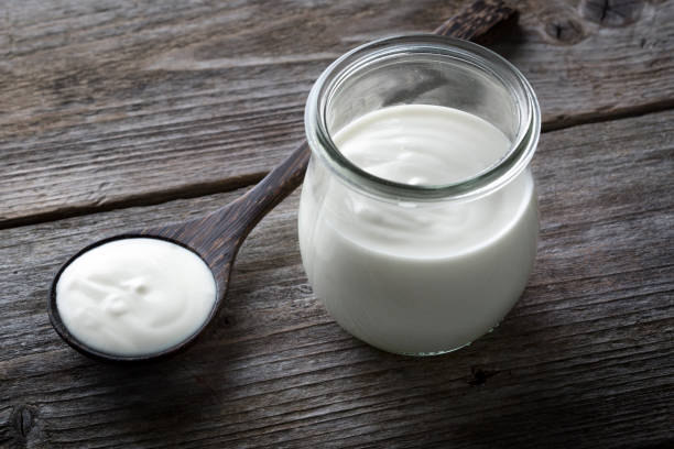 istock Yoghurt pot, wooden table background 1203401393