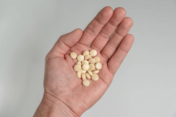 istock round beige pills in the palm 1203403945