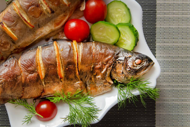 istock baked fish in a plate with vegetables 1203403960