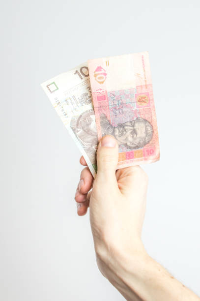 istock 10 UAH and 10 PLN banknotes held in hand. 1203404009