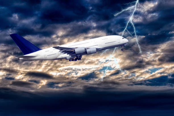 istock A plane flying on background of dark cloudy sky with a lightning. 1203409950