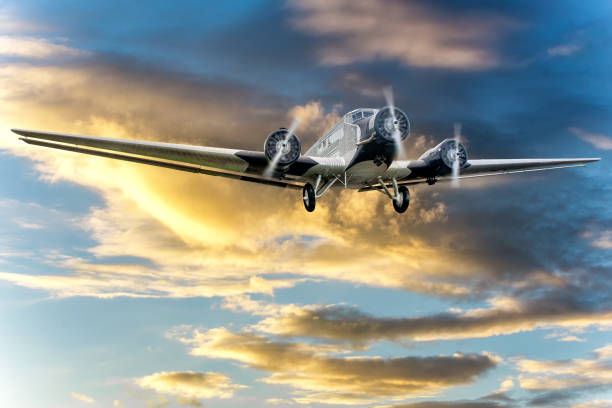 istock Big propeller aeroplane flying on background of sun set sky. 1203410101