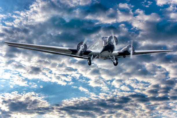 istock Big propeller aeroplane flying on background of cloudy blue sky. 1203410130