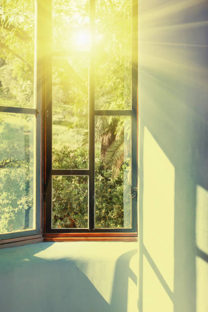 istock Sunbeams passing through vintage window into room 1203411171