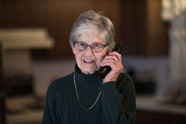 istock Senior woman looking at camera while on the telephone 1203414313