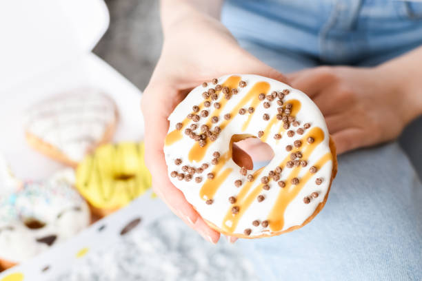 istock Female hand holding delicious donut 1203415623