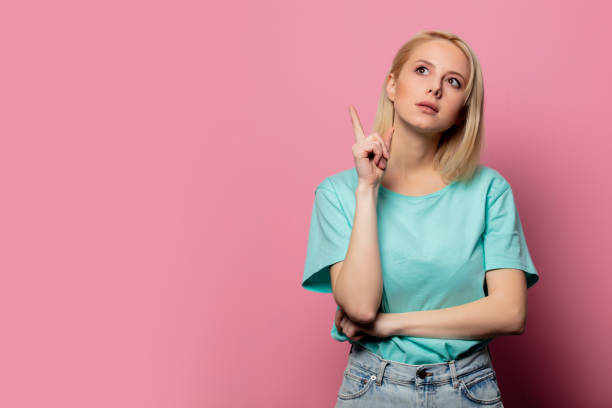 istock Beautiful surprised woman on pink background 1203418034