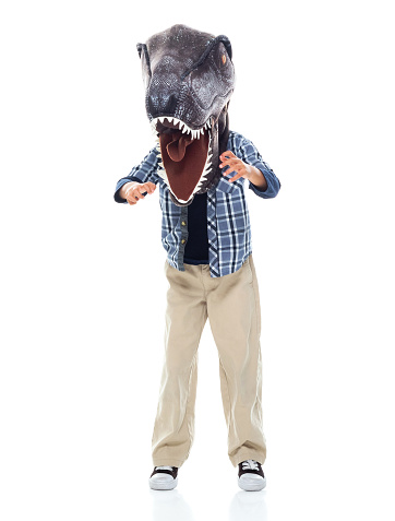 Full length of boys standing wearing costume and wearing wearing dinosaur mask mask