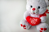 White teddy bear holds red heart with text I Love You