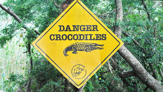 Danger crocodiles sign at the head of the boardwalk along the estuary in Saint Lucia, South Africa