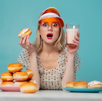 Beautiful woman in 90s clothes with donuts and milk