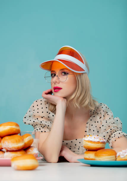 istock Beautiful woman in 90s clothes with donuts 1203427268