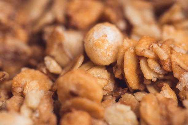 Useful and tasty muesli with nuts, rasins and flakes. Selective focus macro shot with very shallow depth of field. Healthy and vegetarian lifestyle