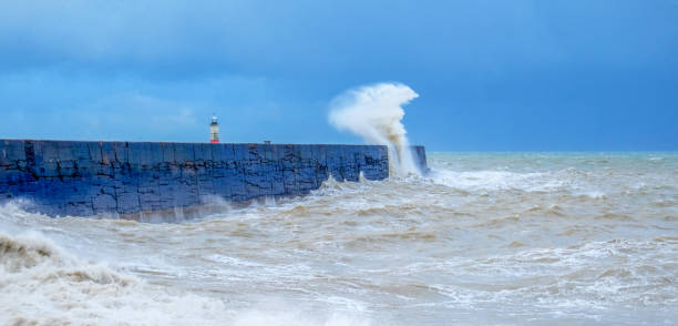 ściana portu z ostrym burzliwym morzem rozbijającym się o ścianę powodującą rozmycie morza i ruch - lighthouse storm sea panoramic zdjęcia i obrazy z banku zdjęć