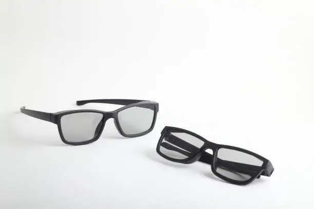 Photo of Two pairs of 3d glasses for cinema. Watching movie in 3d. Black glasses on white background