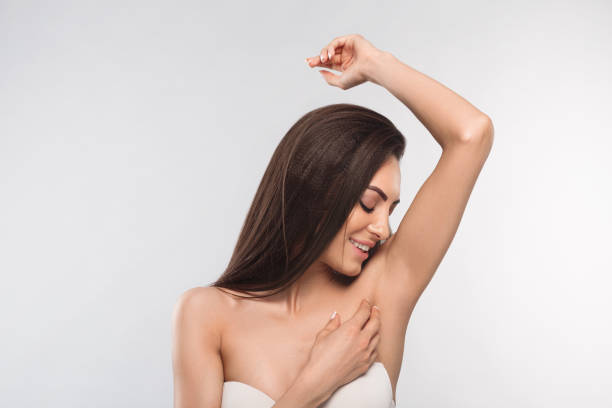 Armpit epilation, lacer hair removal. Young woman holding her arms up and showing clean underarms, depilation smooth clear skin .Beauty portrait. stock photo