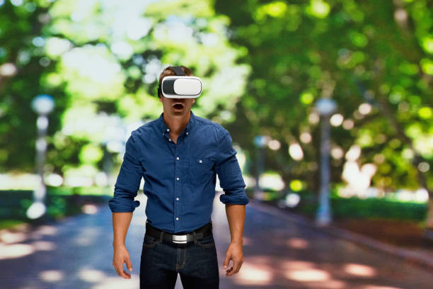 istock Caucasian young male standing in front of public park and using augmented reality 1203430484