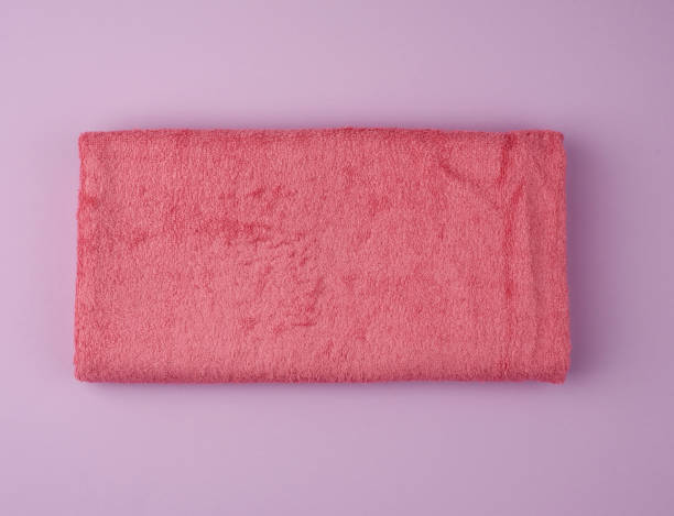 istock folded bath terry pink towel on a white background 1203431948