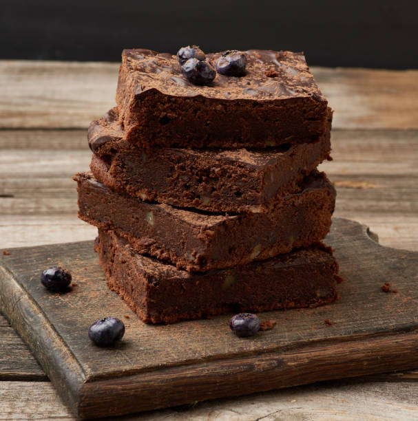 istock stack of square baked slices of brownie chocolate cake with walnuts 1203433031