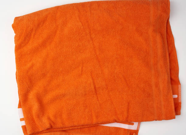 istock folded bath terry orange towel on a white background 1203433748
