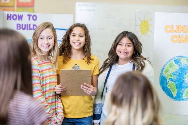 Diverse group of elementary school girls presenting their group science fair entry