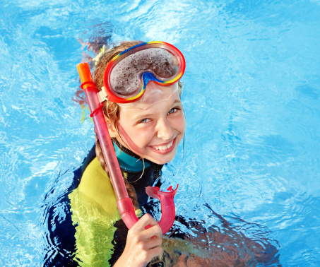 Child in swimming pool learning snorkeling. Sport.