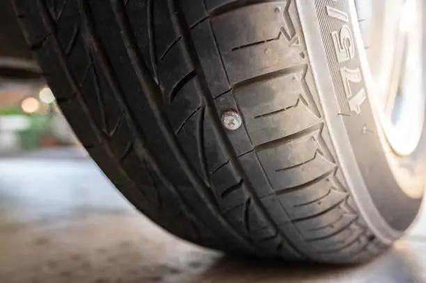 Close-up nail or screw stick on the car tire, the most problem of flat tire