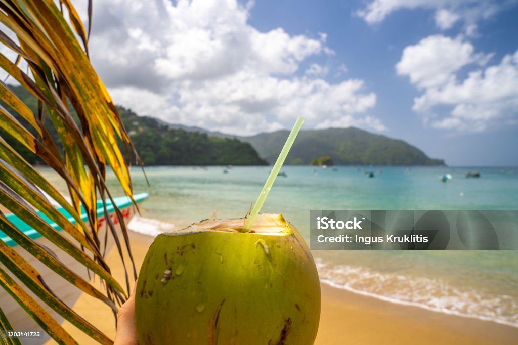 Coconut drink on sand beach, summer vacation on beach Coconut drink on sand beach, summer vacation on beach on the remote island in the middle of the ocean. Trinidad - Trinidad And Tobago Stock Photo