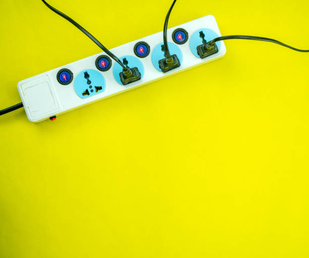 istock Electric power socket and plug on yellow paper background. 1203455256