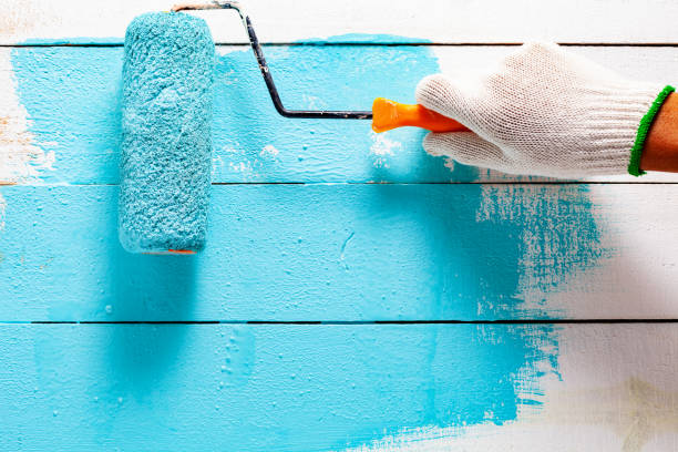 istock Hand painting blue color on white wooden table. 1203455284