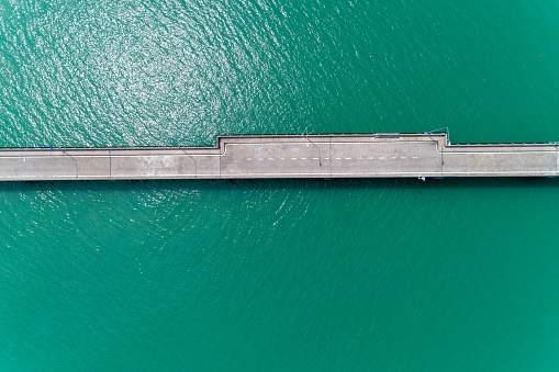 Aerial top view drone shot of small bridge in the sea image transportation background concept