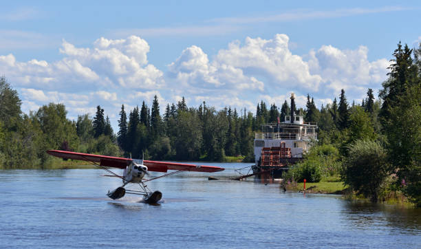 Float plane landing, Alaska Float plane landing on the Chena River in Fairbanks, Central Alaska, old time steamboat in the background. fairbanks photos stock pictures, royalty-free photos & images