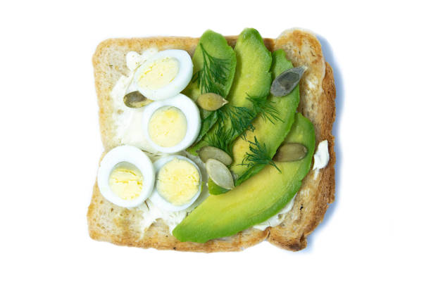 istock Sandwich with avocado seeds and eggs isolated on a bobl background 1203458330