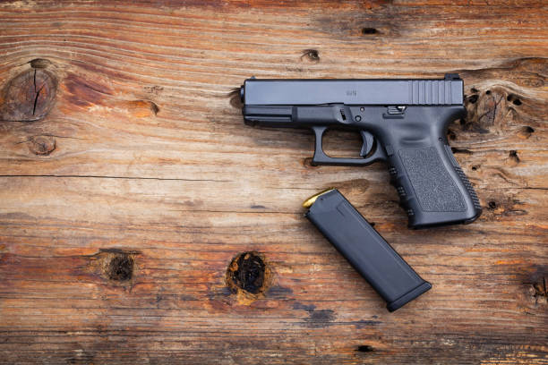 istock 9 mm pistol Gun with ammunition on old wooden background. 1203468165
