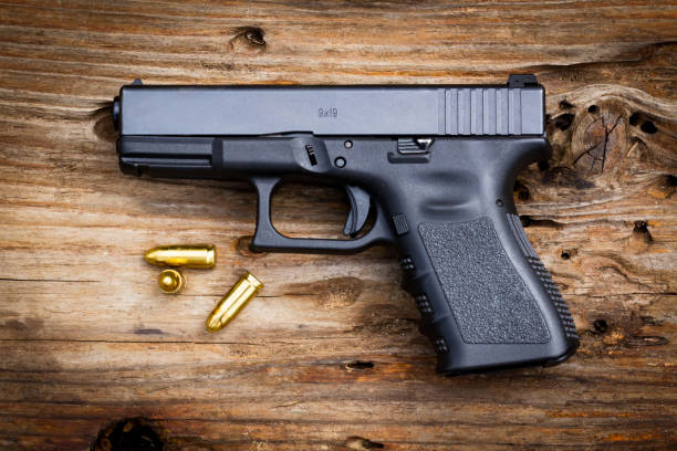 istock 9 mm pistol Gun with ammunition on old wooden background. 1203468166
