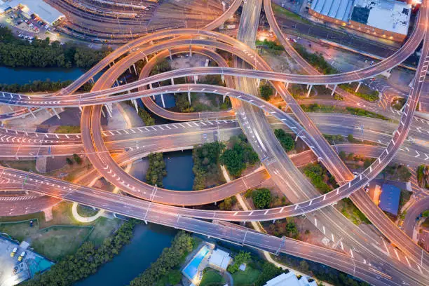 Aerial of a Highway Junction Intersection and Railroad Tracks at sunset, Brisbane Airport Link, Australia. Converted from Raw.