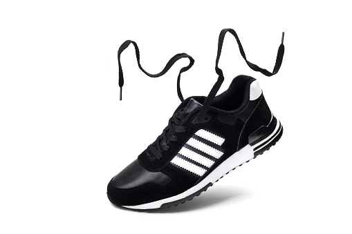 Shoes for the sport. Flying men's black running Shoe with fluttering laces isolated on a white background.