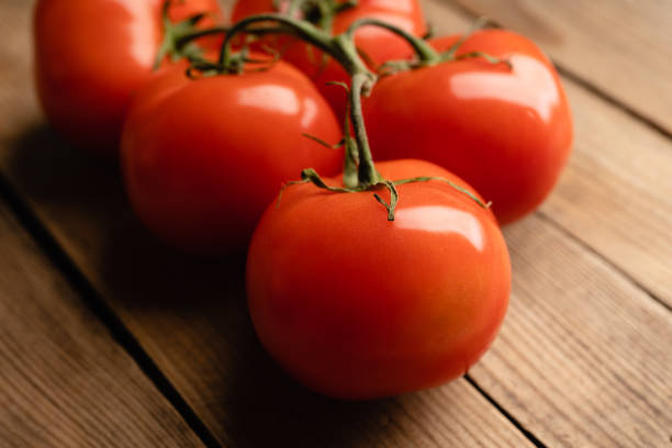 istock Freshly harvested tomatoes on the rustic background 1203472614
