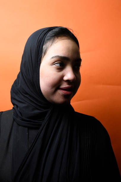 ung vacker muslimsk flicka bär hijab över på orange bakgrund , flicka i arabiska traditionella abbaya - iranian girl bildbanksfoton och bilder