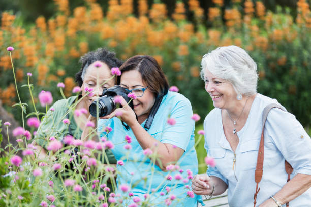 istock Three senior women taking photos in garden 1203477450