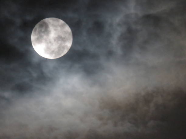 istock Hazy Storm Clouds Mask a Full Moon at Night 1203478970