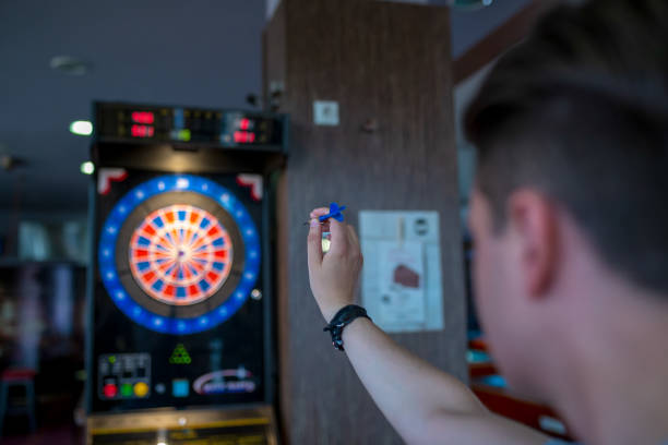 istock man playing a game of darts, focus on target 1203485901