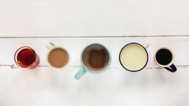 istock Five different hot drinks on white wooden table. Hot chocolate with cinnamon, matcha tea, coffee espresso, tea, latte. Top view, flat lay. 1203491893