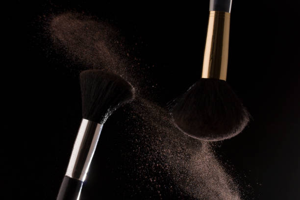 istock Make-up brush with pink powder on black background 1203492611