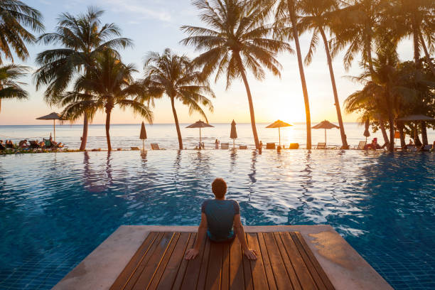 летний отдых в роскошном пляжном отеле, турист, отдыхающий возле роскошного бассейна - tropical hotel стоковые фото и изо�бражения