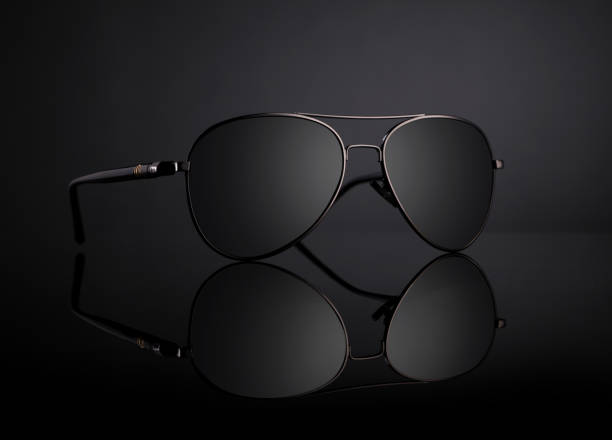 istock Black Aviator Sunglasses with Reflection on Black Background 1203493855